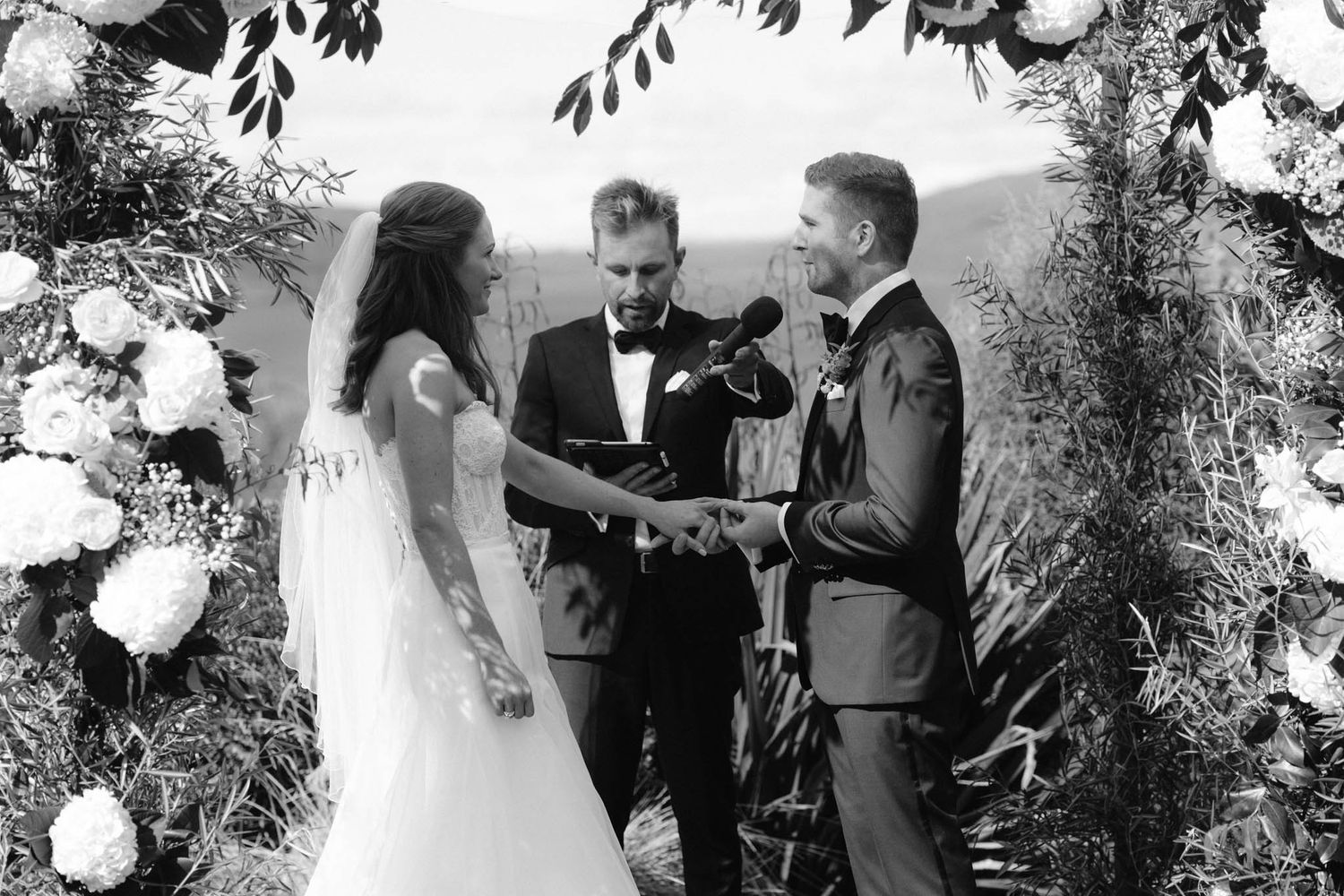 A wedding couple and guests share intimate candid moments during an outdoor garden wedding celebration.