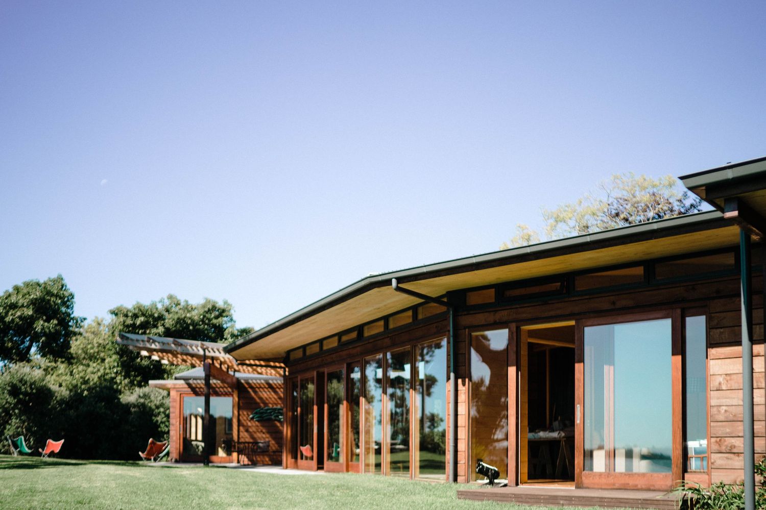 Panoramic view of a modern architectural building with long horizontal lines against blue sky.