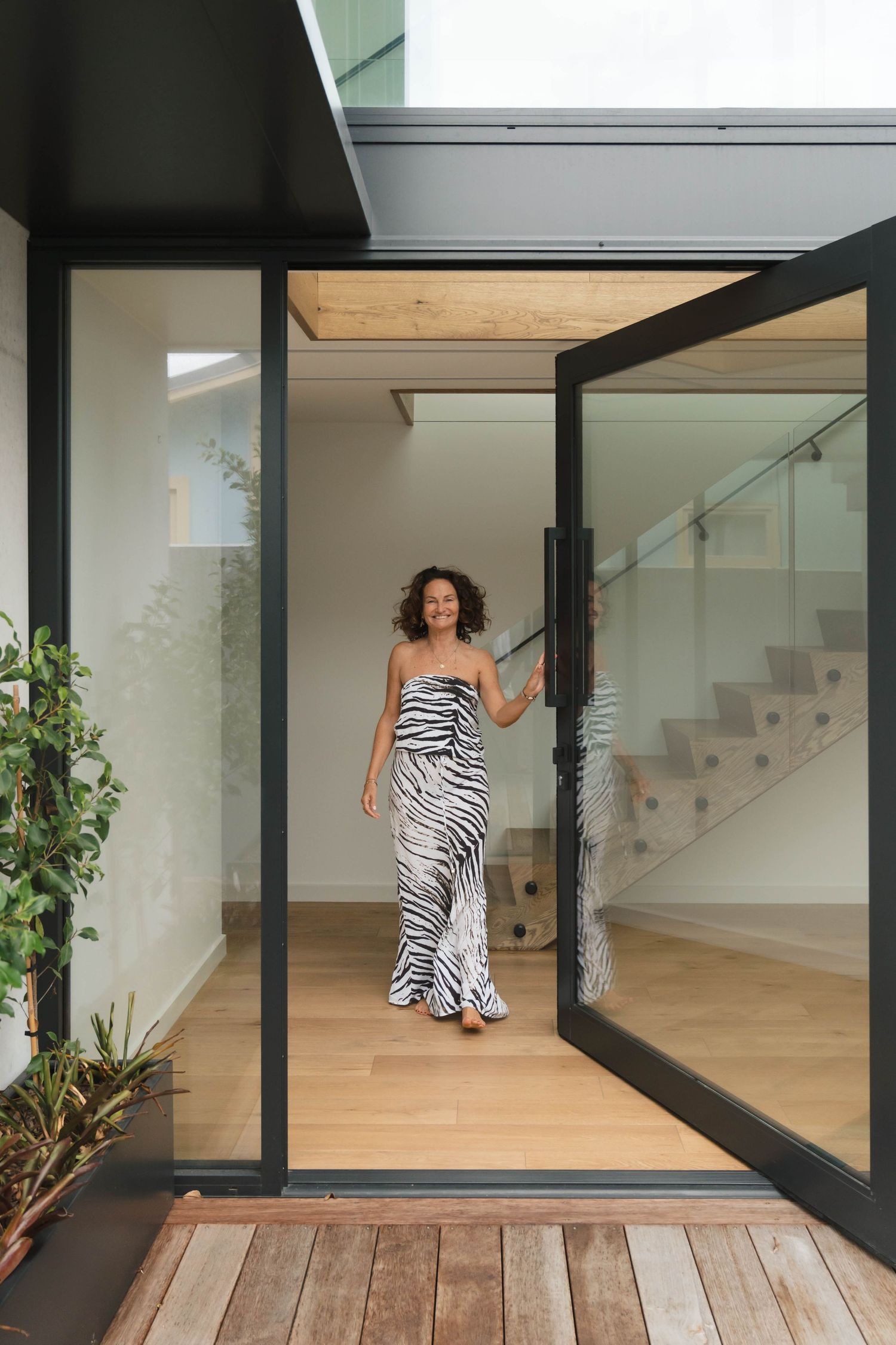 Contemporary home interior with glass sliding doors opening to wooden deck and natural light.