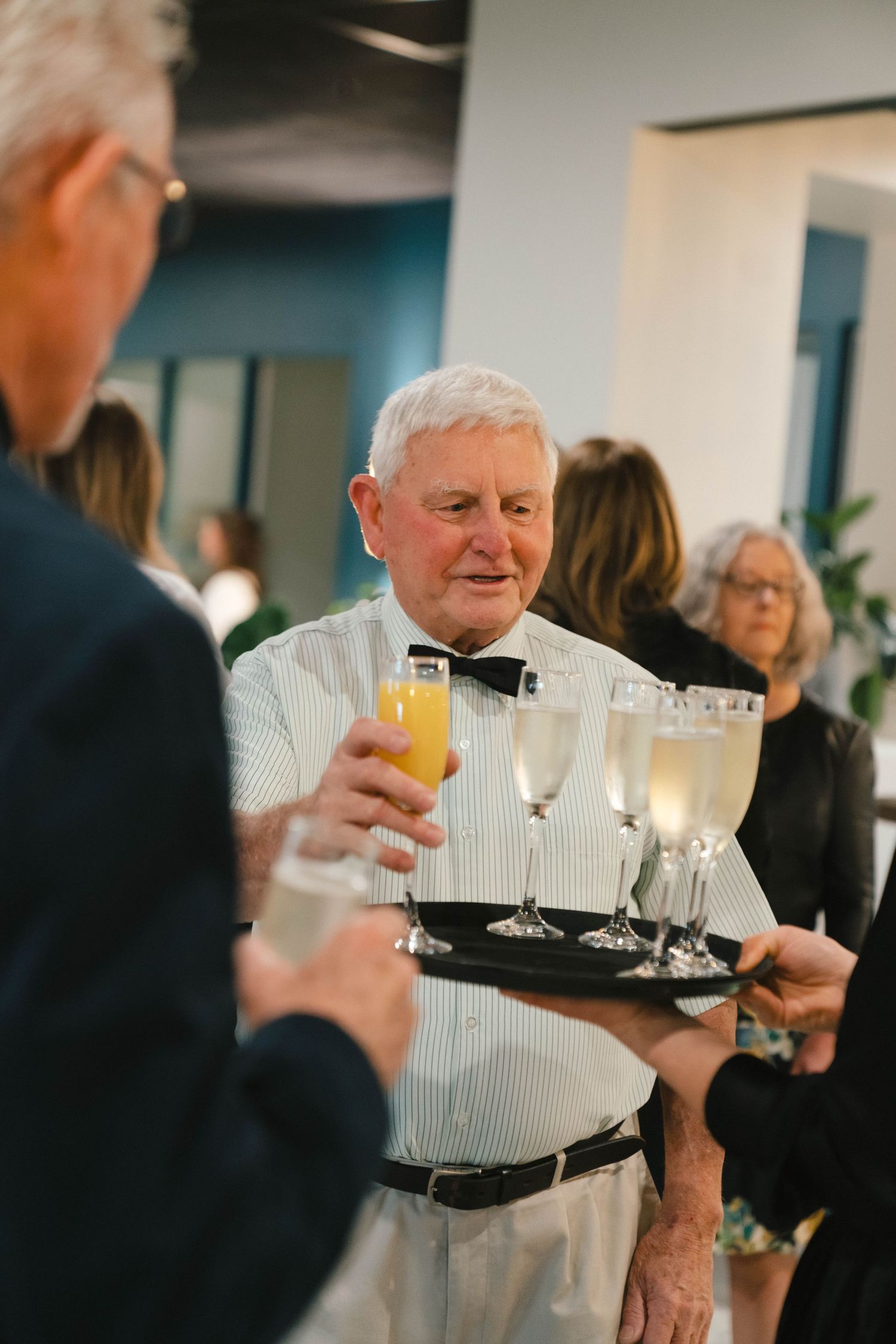 People raising glasses filled with beverages during an elegant celebration.