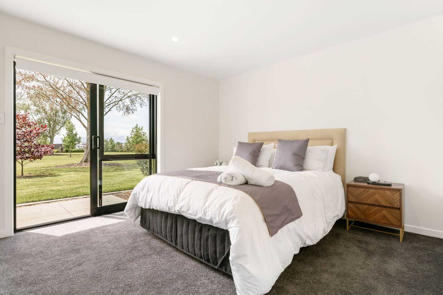 Contemporary bedroom with large windows offering views of the countryside.