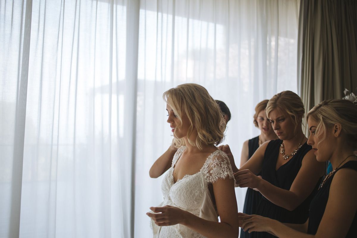 Group of people sitting at a table together with bright window light coming through sheer curtains.