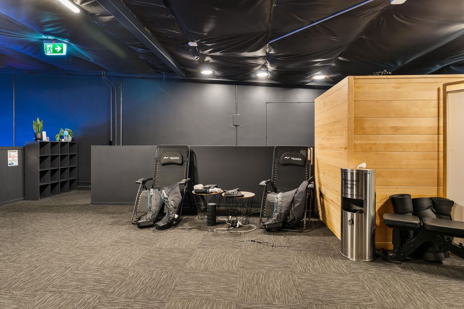 Training area with wooden panels and grey carpeted flooring in a fitness facility.