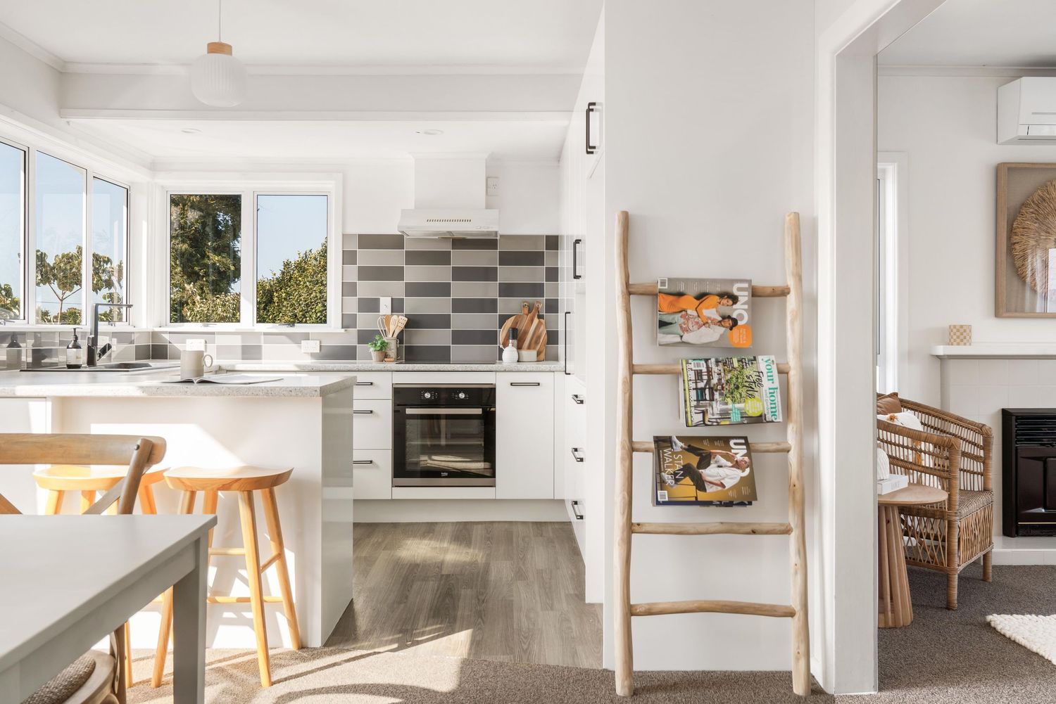 Open concept living space with modern kitchen and dining area in neutral tones.