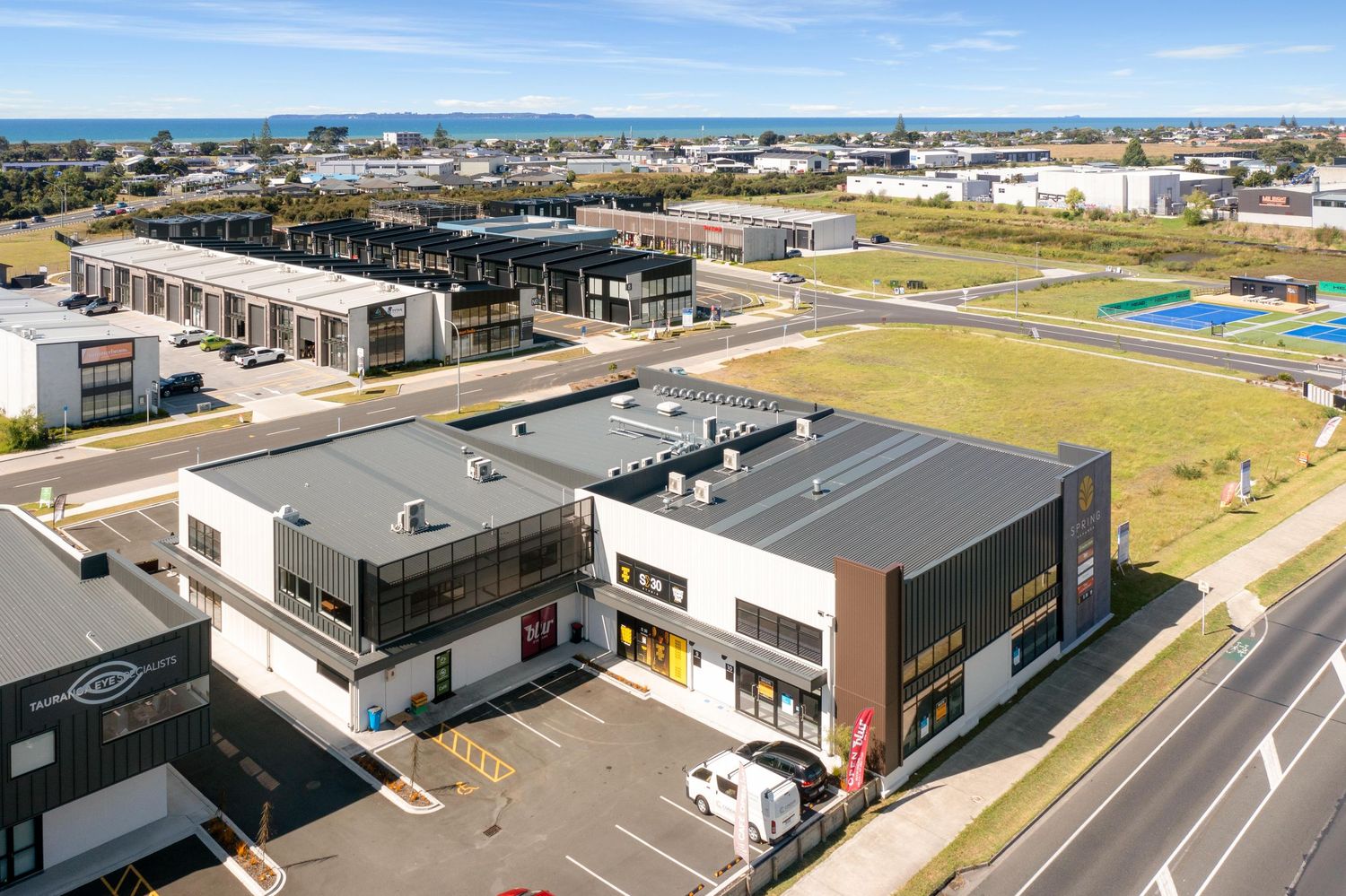 Bird's eye view of a commercial development with parking areas and retail buildings.