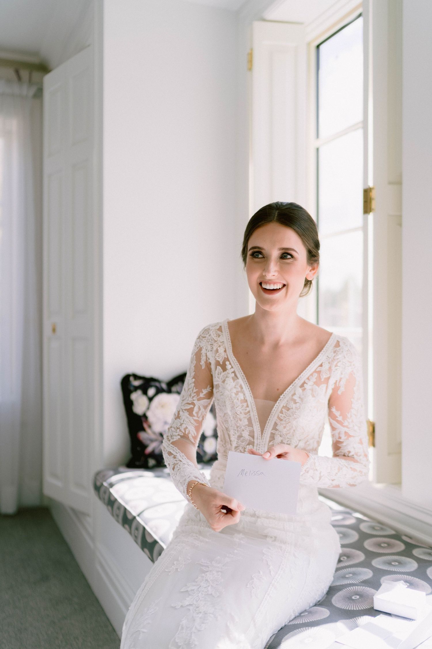 A series of joyful moments in a bright white room as someone wearing a lace wedding dress sits by a window.