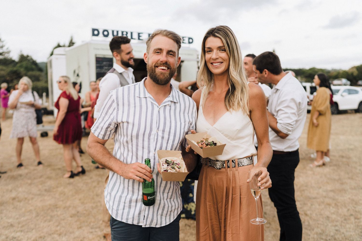 Wedding guests mingling outdoors at a casual daytime reception.
