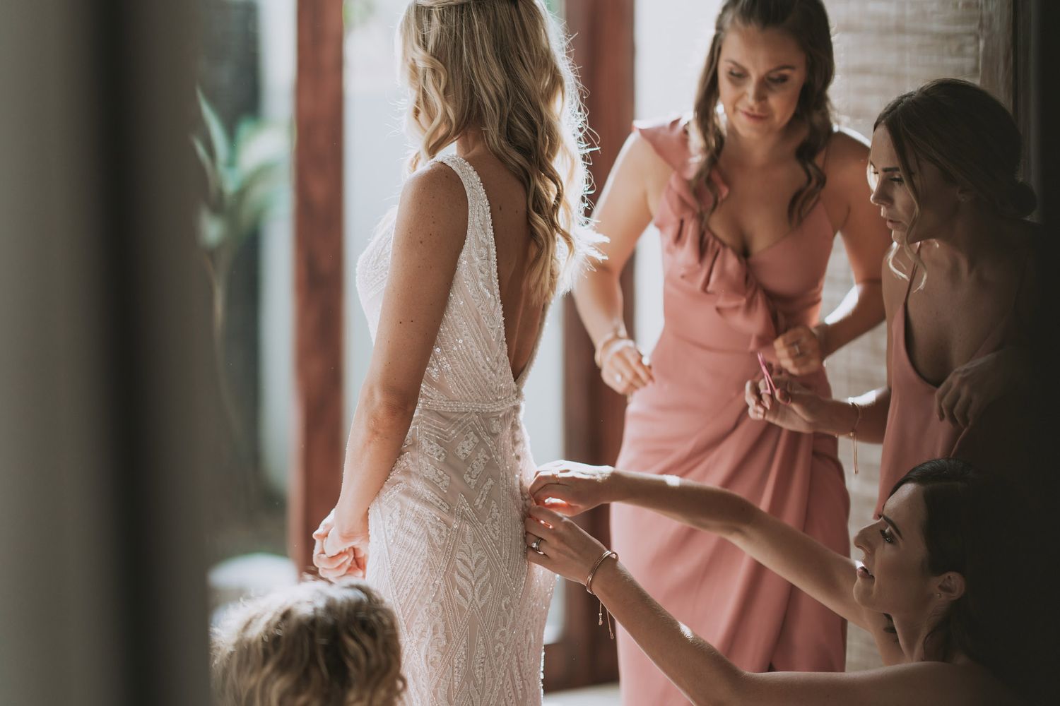 People in coordinating pink and white formal attire gathered in an elegant indoor setting.