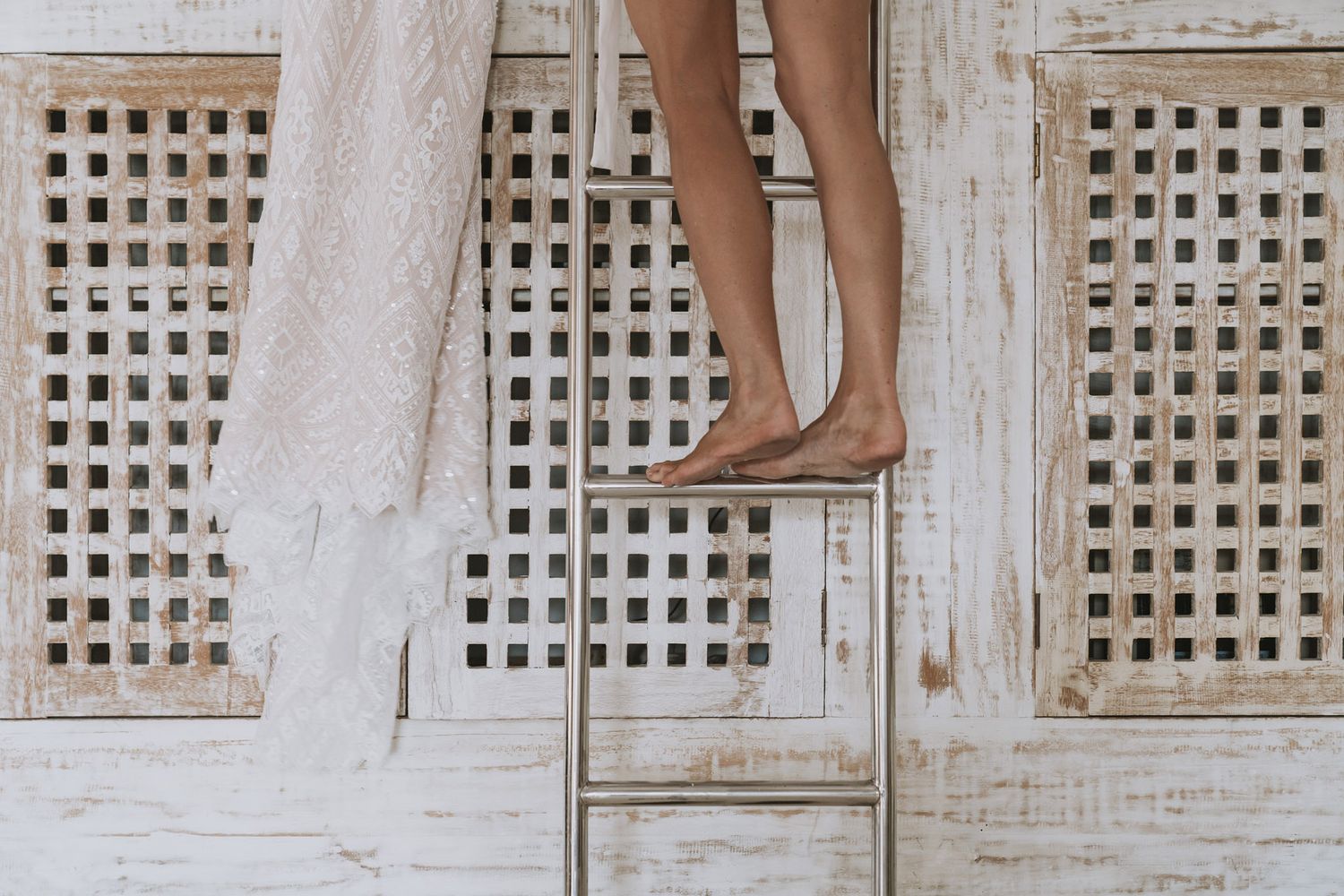 White latticed window frames on a beige wall create a minimalist architectural pattern.