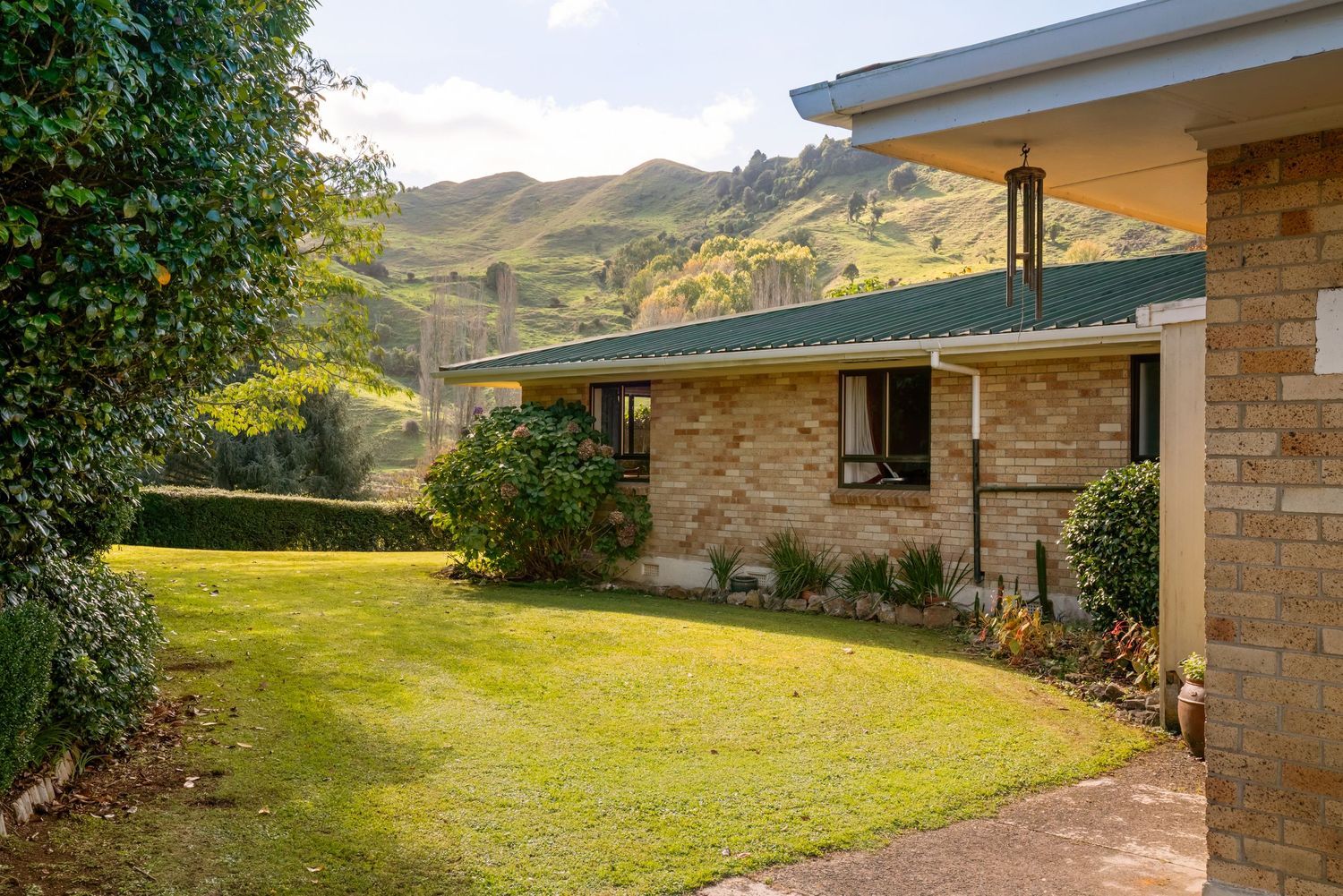 Exterior view of modern ranch house with brick facade and landscaped yard.
