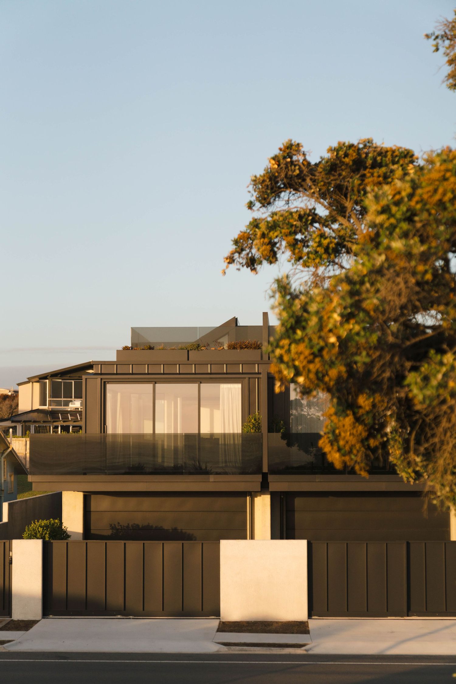 Contemporary black and white residential buildings with minimalist architecture among autumn trees.