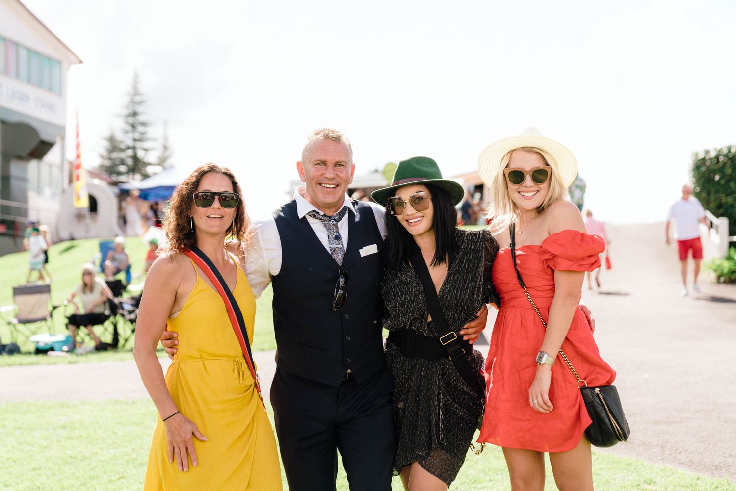 Group photo of attendees in colorful attire at a summer outdoor event.