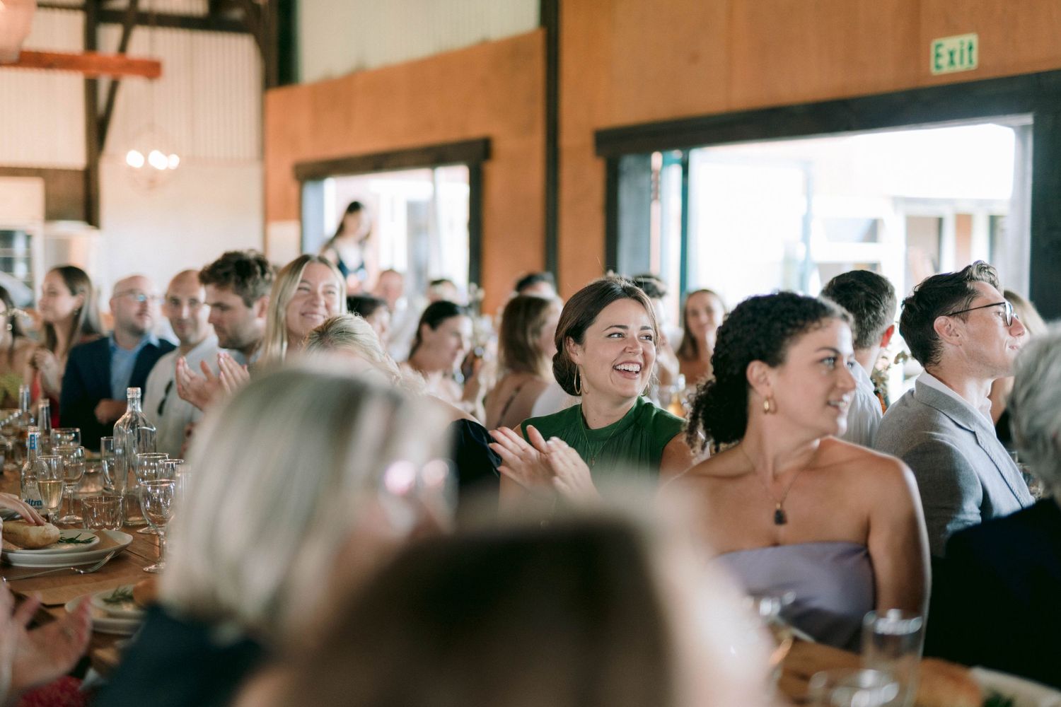 Wedding reception guests enjoying a celebration in a rustic indoor venue.