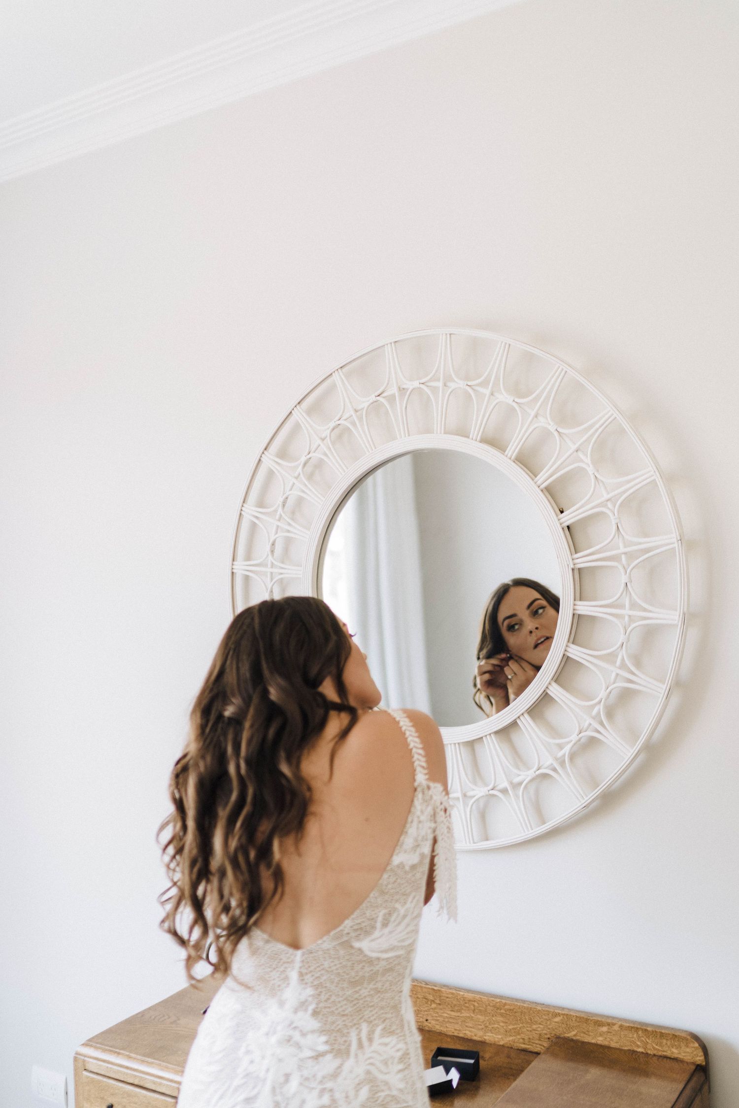Series of photos showing reflection in a decorative white sunburst mirror against a light wall.