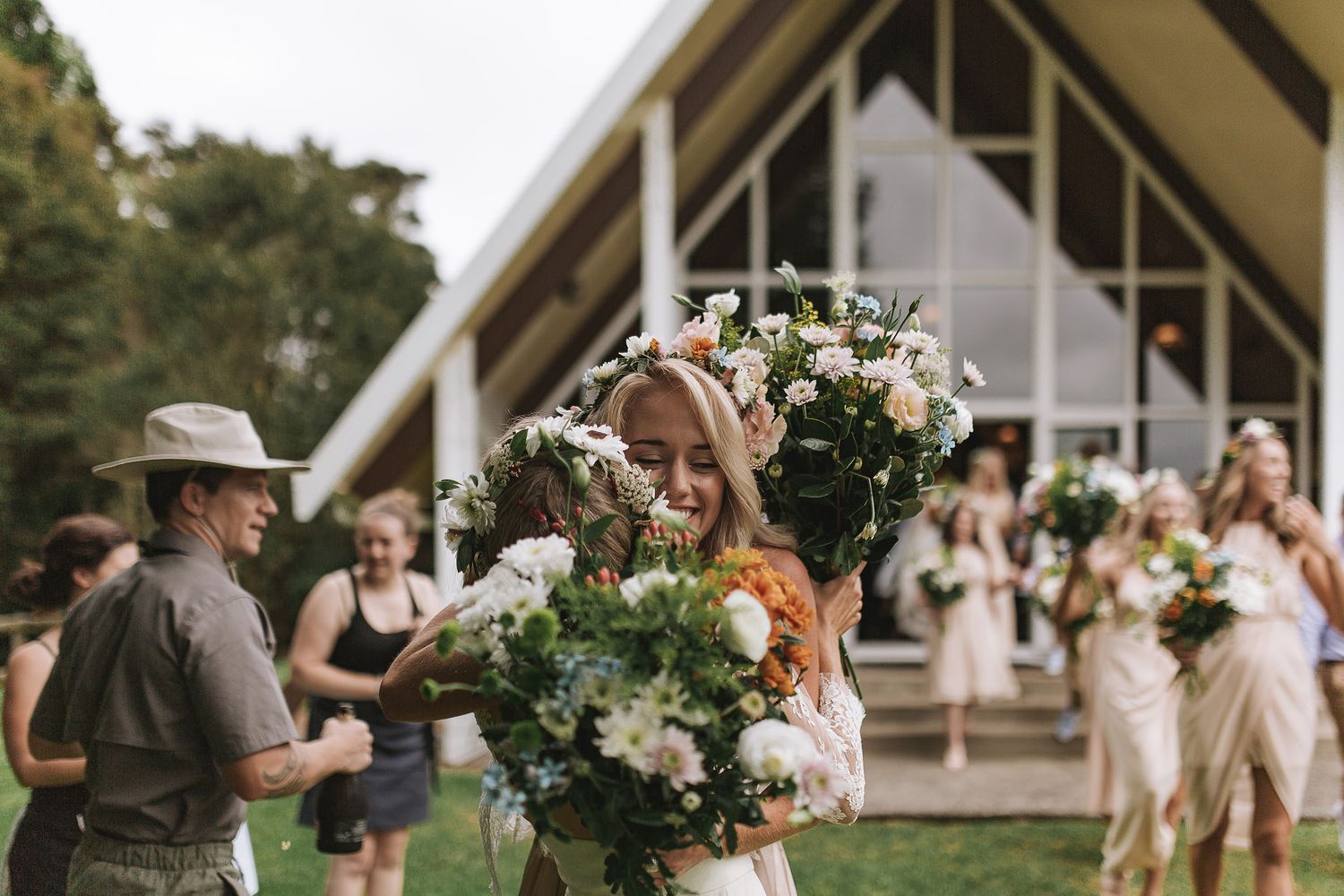 Elegant wedding floral arrangements with white flowers and greenery line a rustic outdoor ceremony venue.