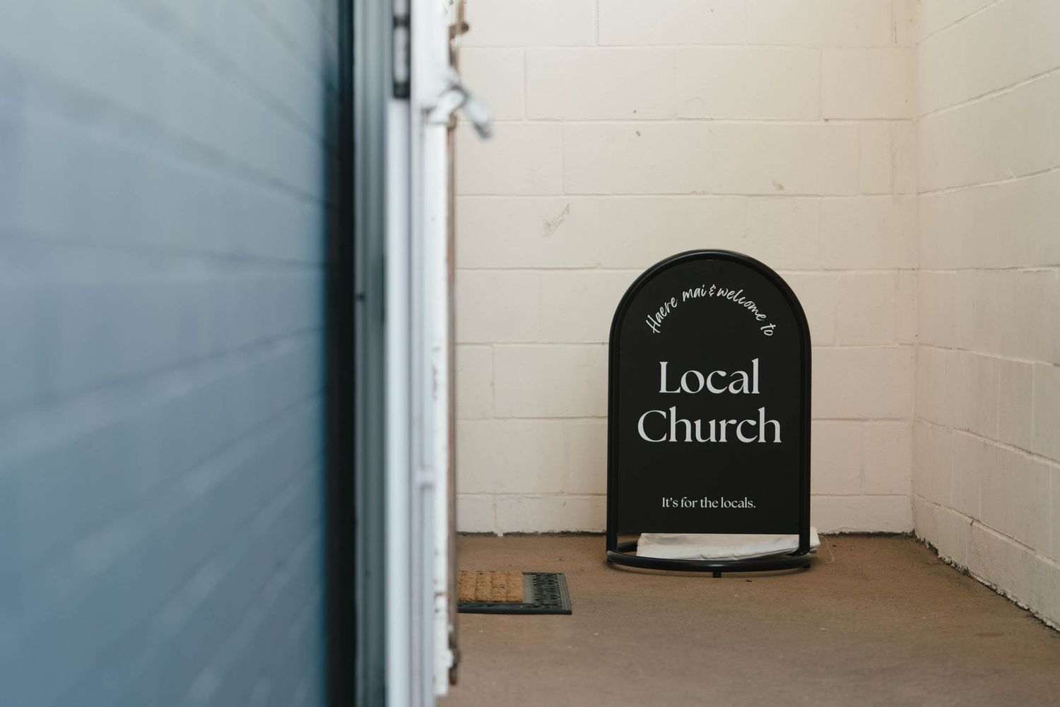 A row of black arched signs reading Local and Church mounted on white walls in a dimly lit interior.