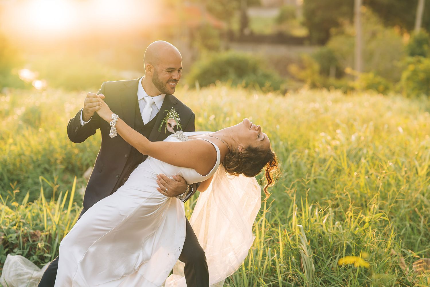 A romantic sunset photoshoot series of a couple embracing in a golden wildflower meadow.
