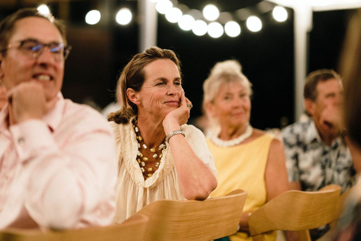 Wedding guests enjoying speeches and entertainment during an evening reception.