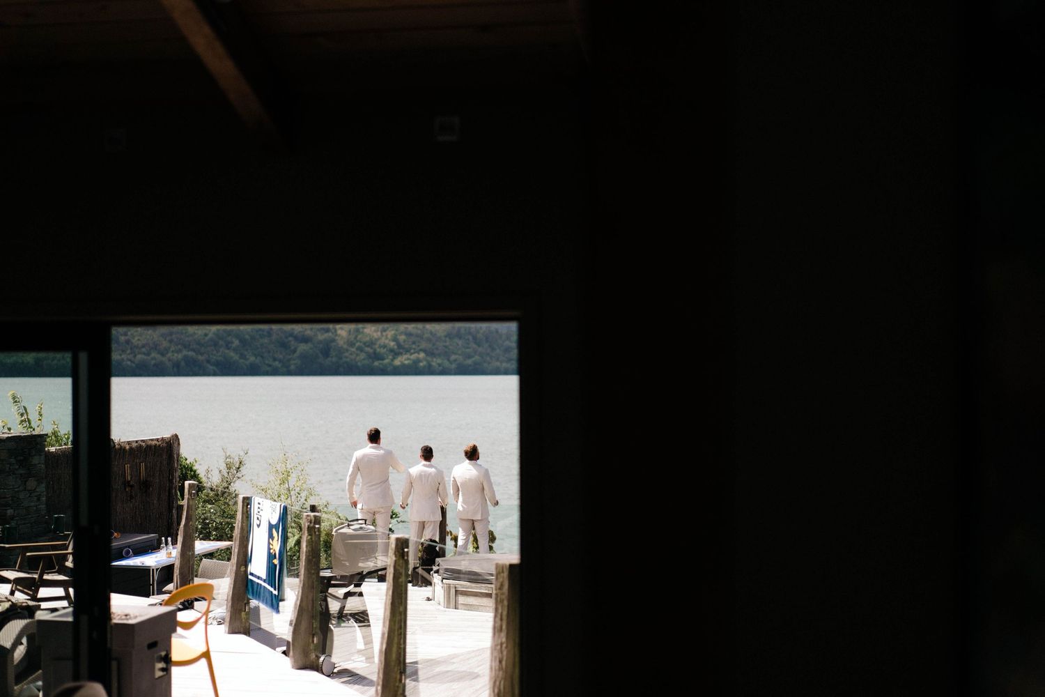 Outdoor wedding venue setup with white chairs and floral arrangements against a natural landscape.