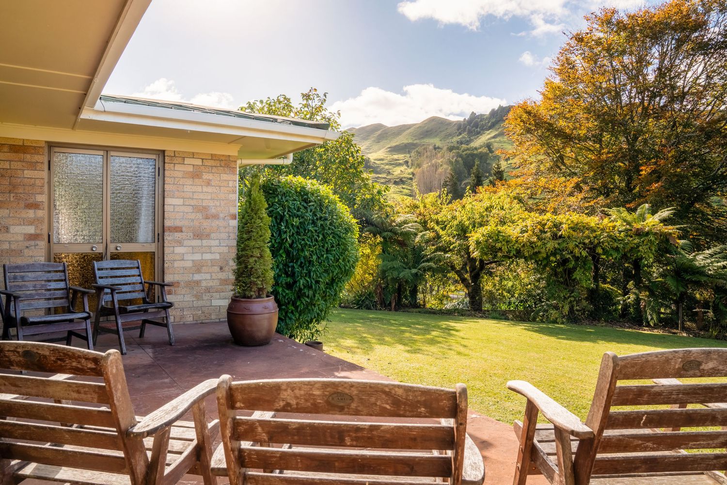 Stone patio with wooden bench seating overlooking scenic mountain views.