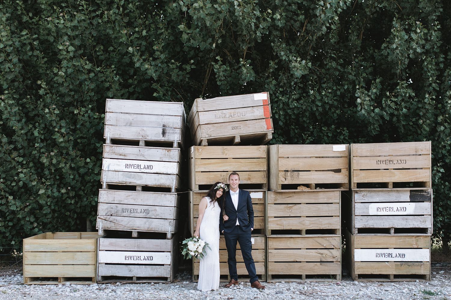A series of wooden storage crates arranged in a line outdoors against a green background.