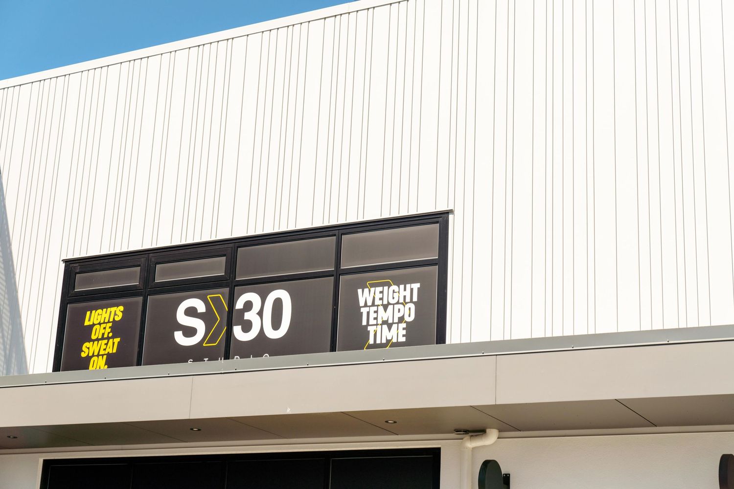 White building exterior with S30 signage and Weight Match text displayed on dark panels.