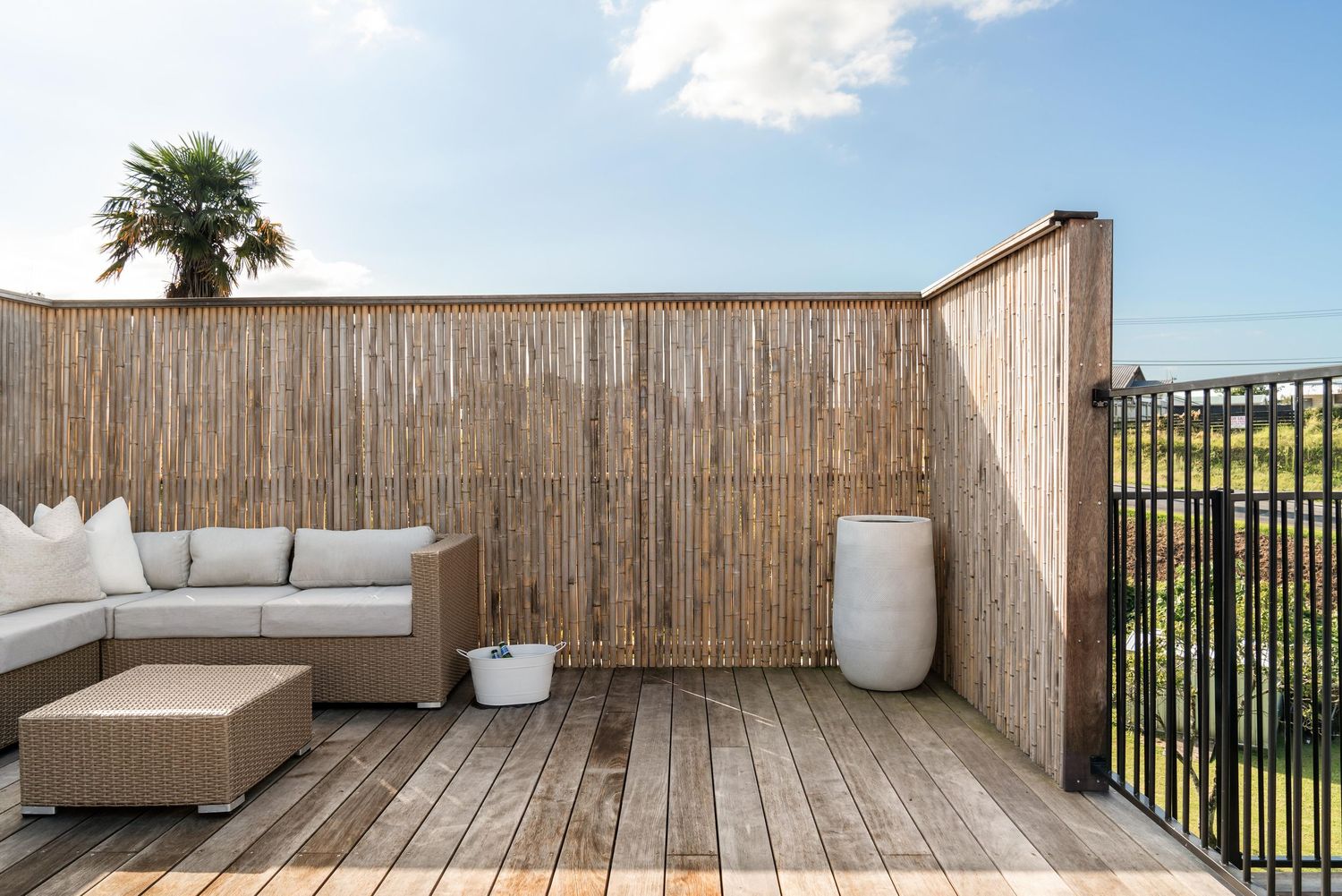 Modern outdoor deck space with wooden privacy fence and comfortable seating area.