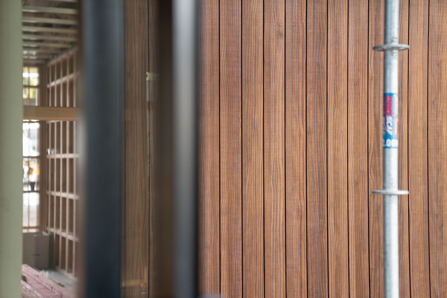 Close-up view of modern wooden slat wall paneling with vertical grain pattern and metal trim details.