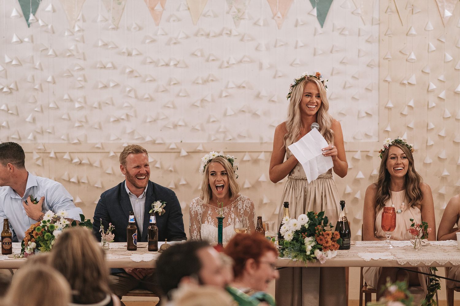 A series of candid wedding reception photos showing guests celebrating with bunting and string lights in a rustic venue.