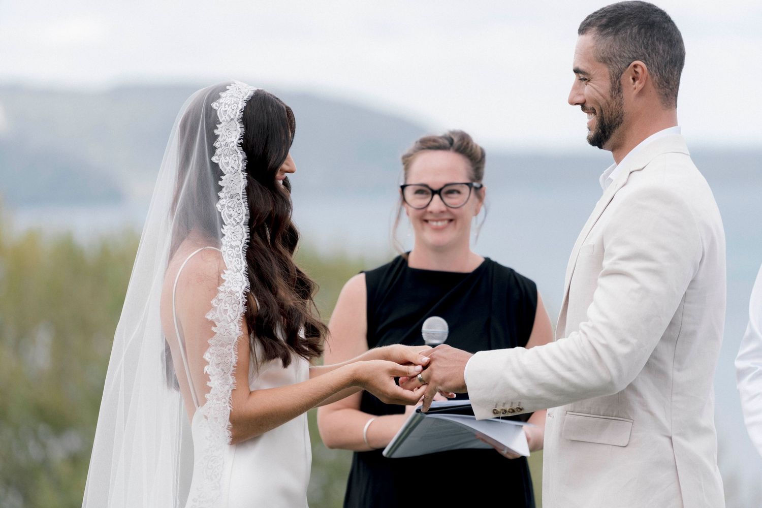 Wedding ceremony taking place on a scenic overlook with mountains in the distance.