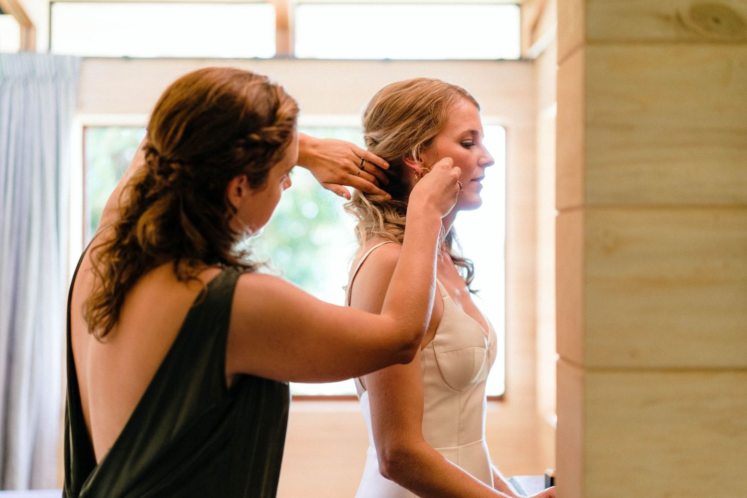 Elegant wedding preparation scene in a sunlit room with wooden walls.