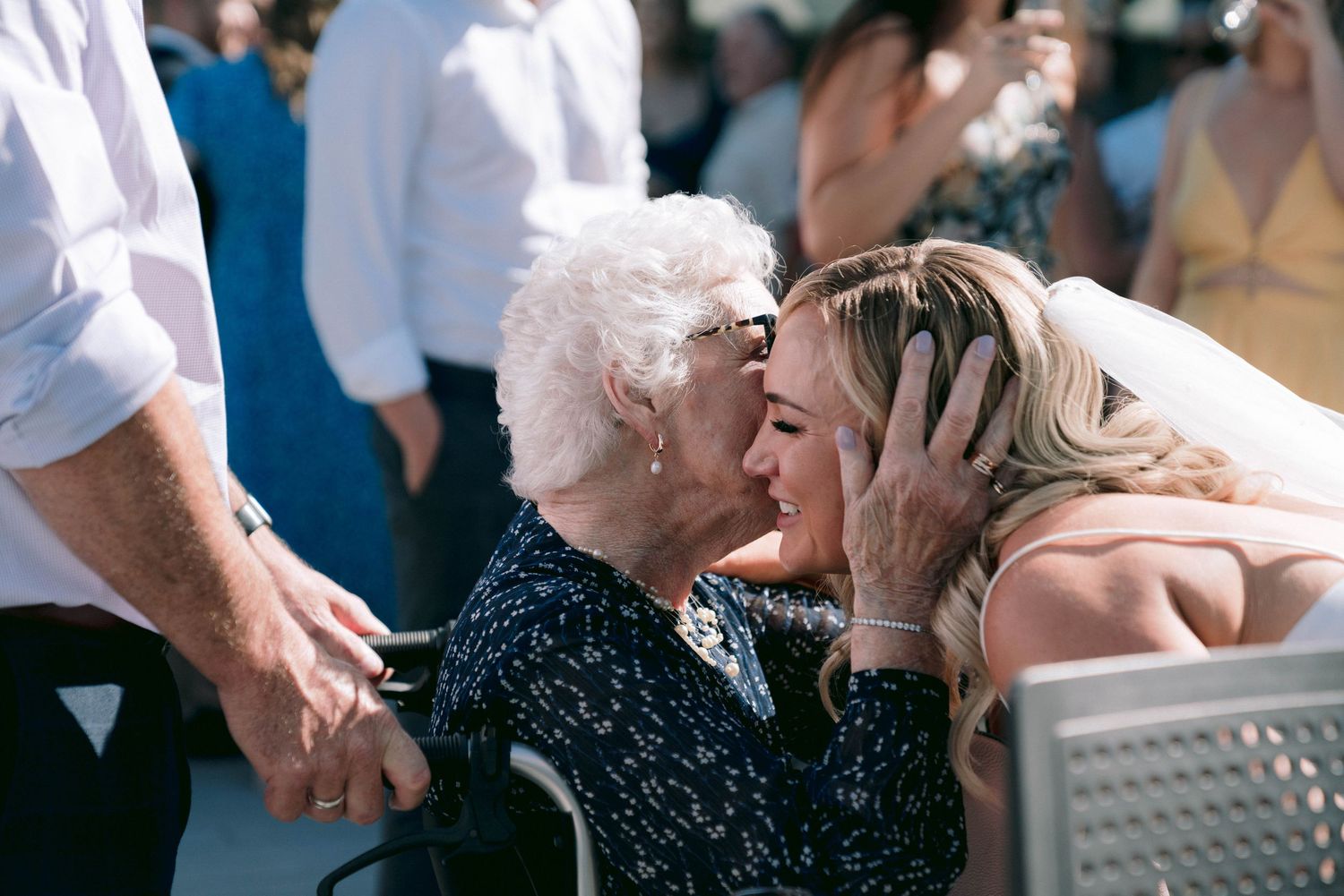 Wedding guests embracing and celebrating during outdoor reception festivities.