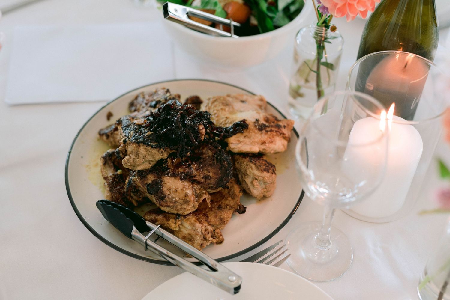 Elegant plated dinner dishes at a wedding reception with mood lighting.