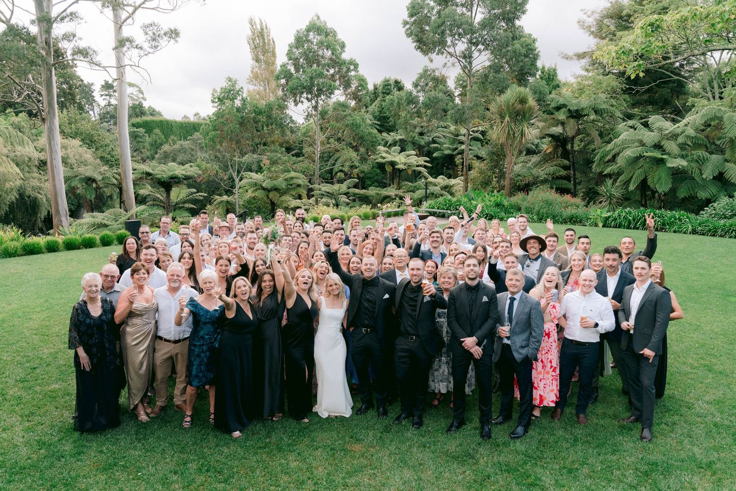 A series of wedding party photos lined up showing large groups of guests and wedding couples posing outdoors in a garden setting.