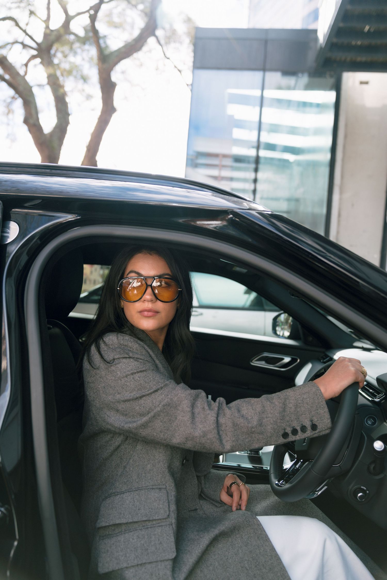 Series of photos showing someone in a gray suit entering and sitting in a black car with sunglasses.