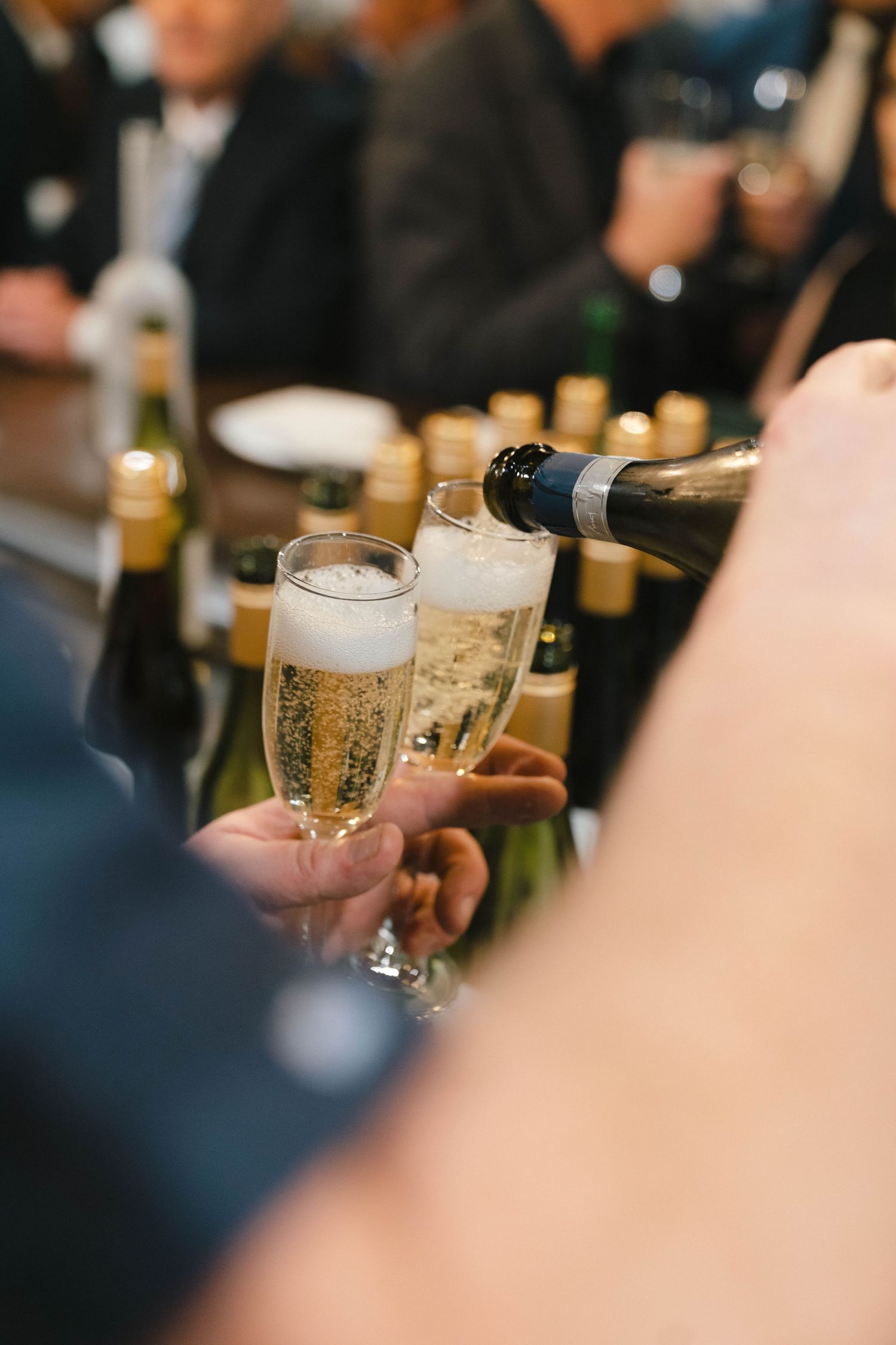 Close-up of champagne glasses being raised during a celebratory toast.