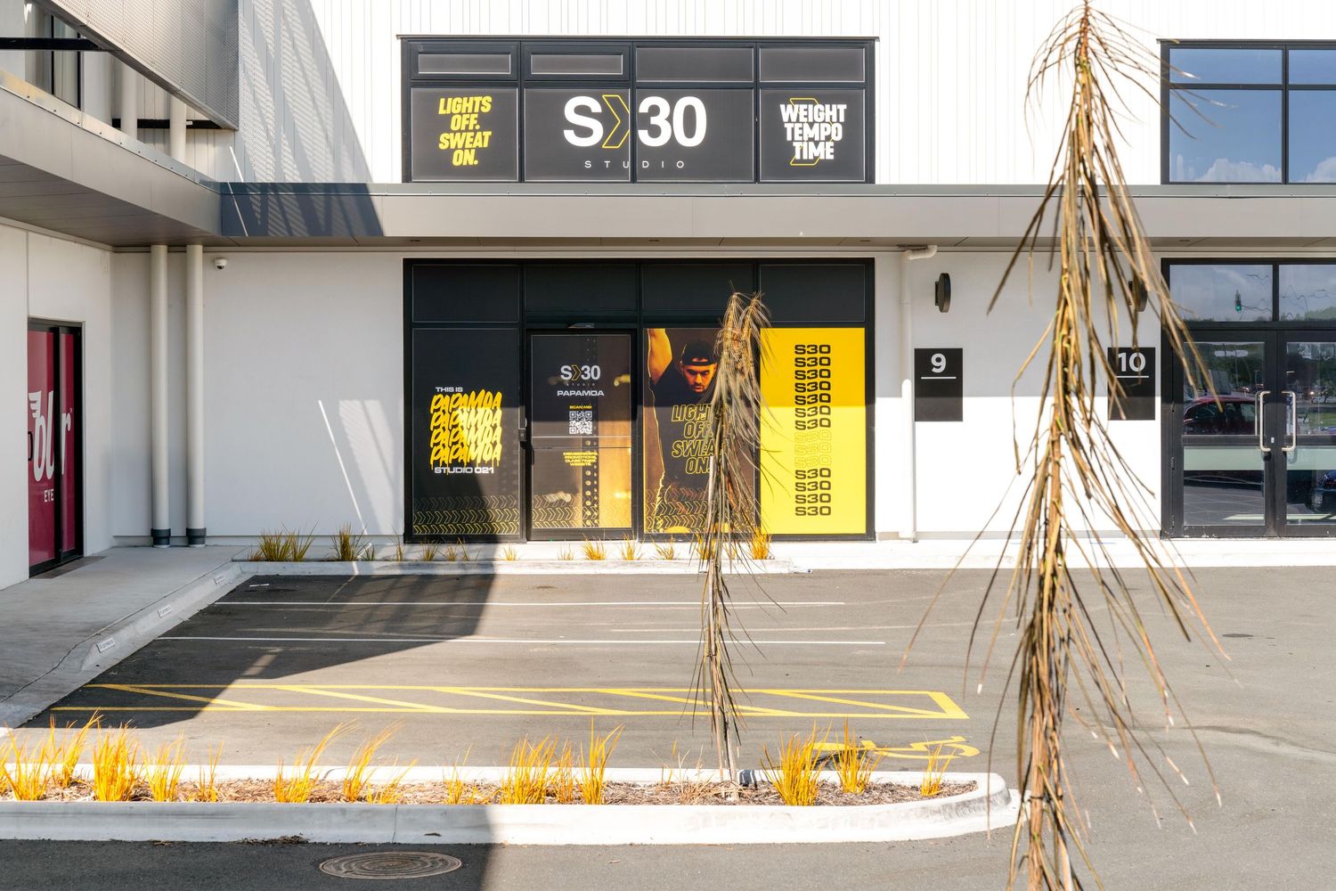 Exterior facade of a modern retail building with large windows and signage.