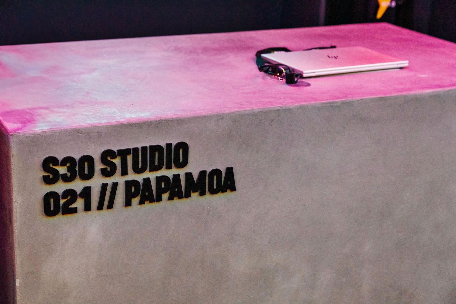 Close-up of pink concrete bench with black text reading 'S30 Studio 021 Papamoa'.