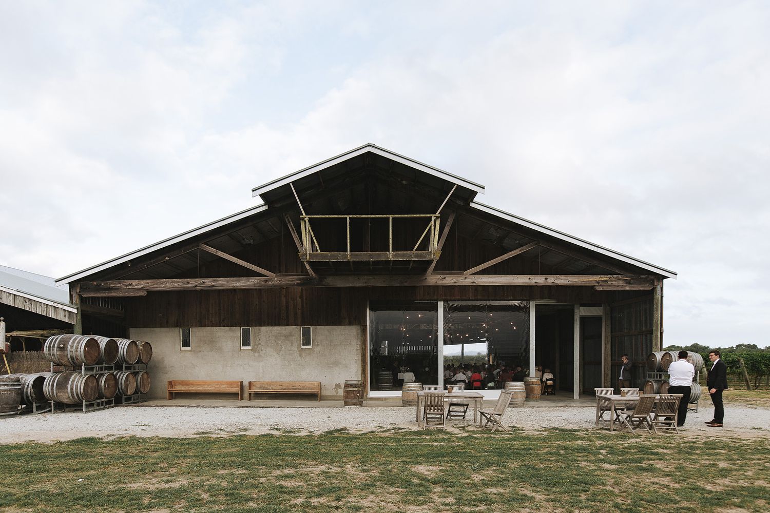 A panoramic view of a large agricultural barn structure with multiple connected sections and open doorways.