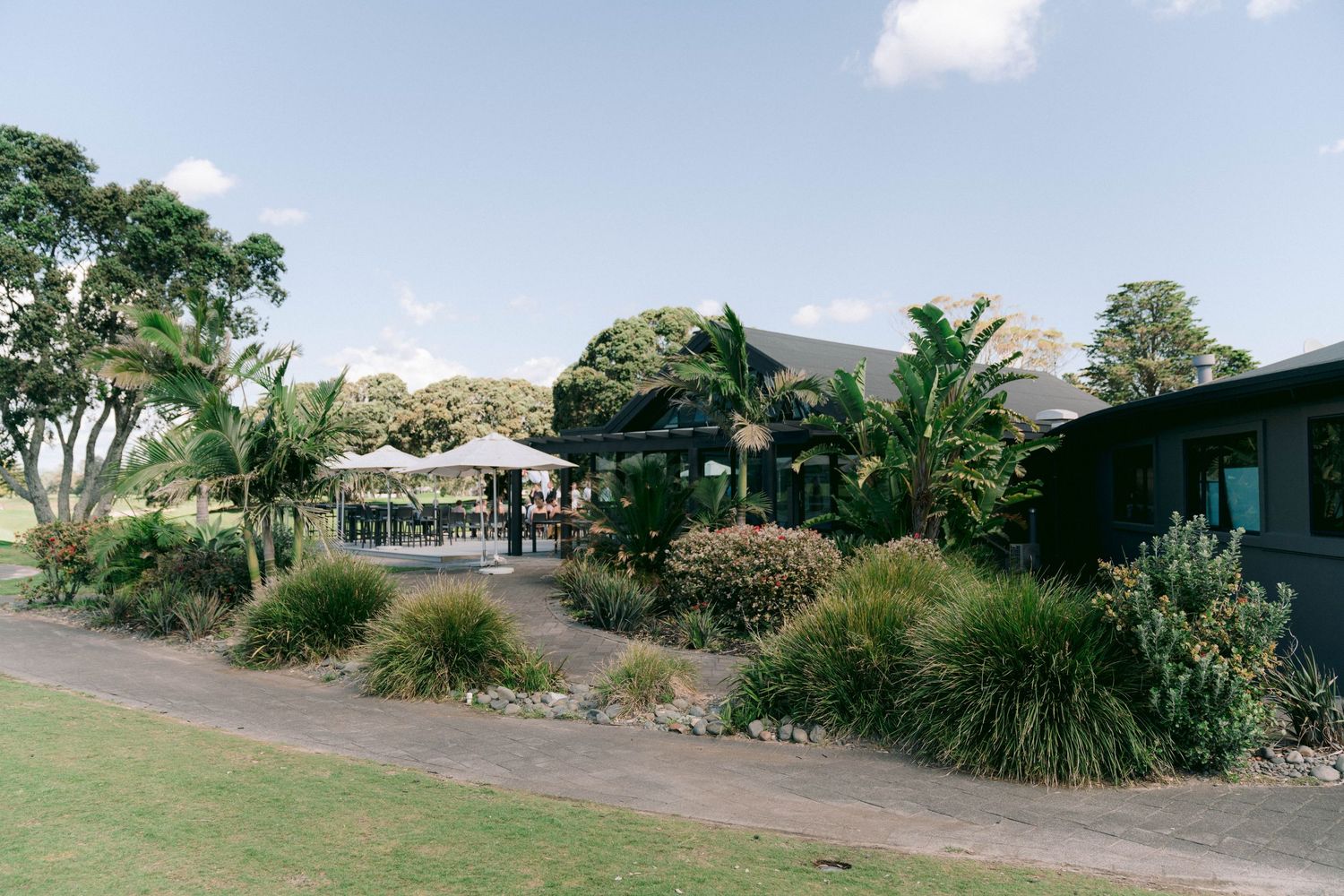 Panoramic view of an outdoor venue with lush tropical landscaping and palm trees.
