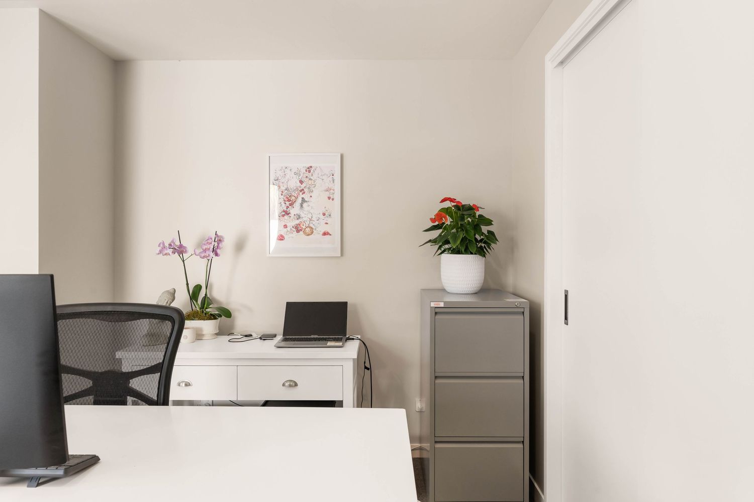 Minimalist home office area with filing cabinets and simple workspace setup.