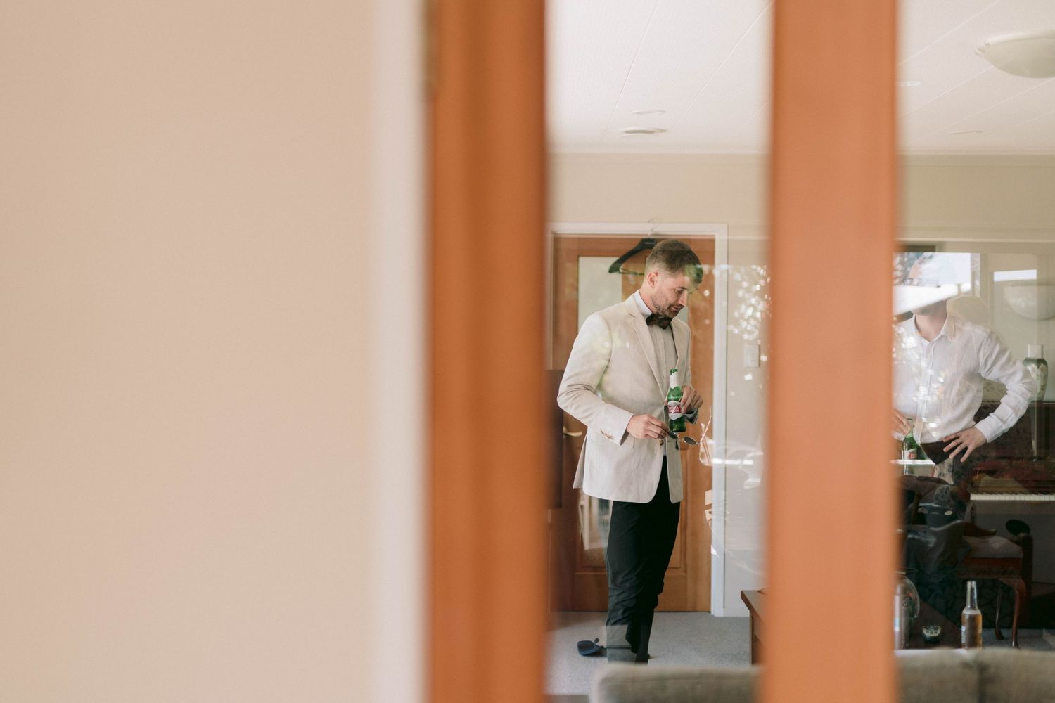Medical personnel in white coats check hospital rooms through a doorway during their rounds.