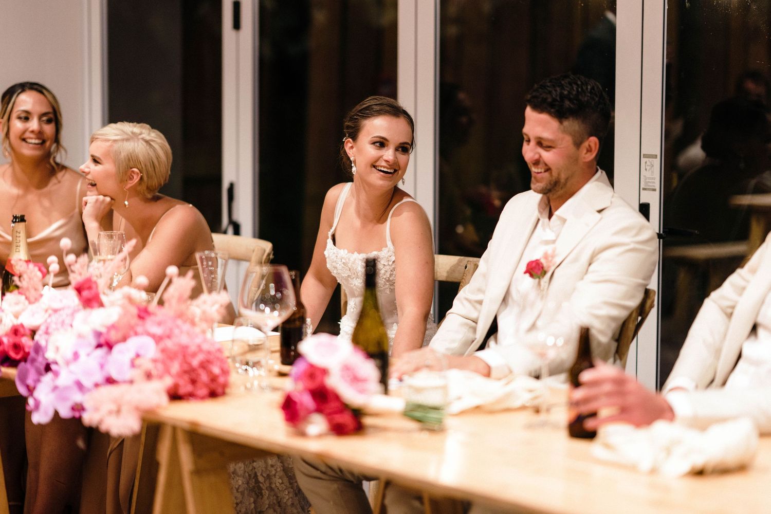 Wedding reception dinner scene with guests enjoying wine and conversation.