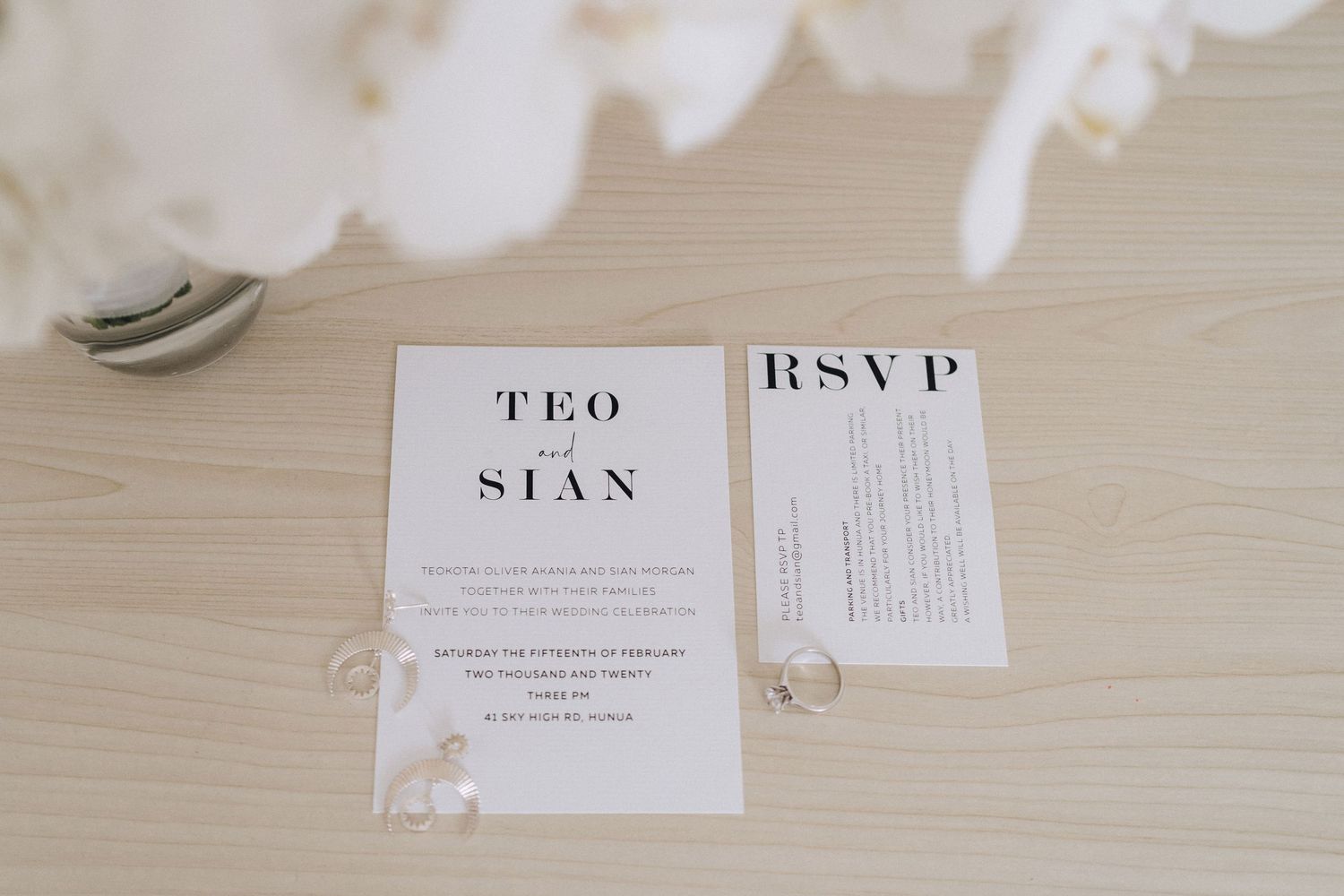 Wedding invitation and RSVP card displayed on a light wood surface with minimal design.