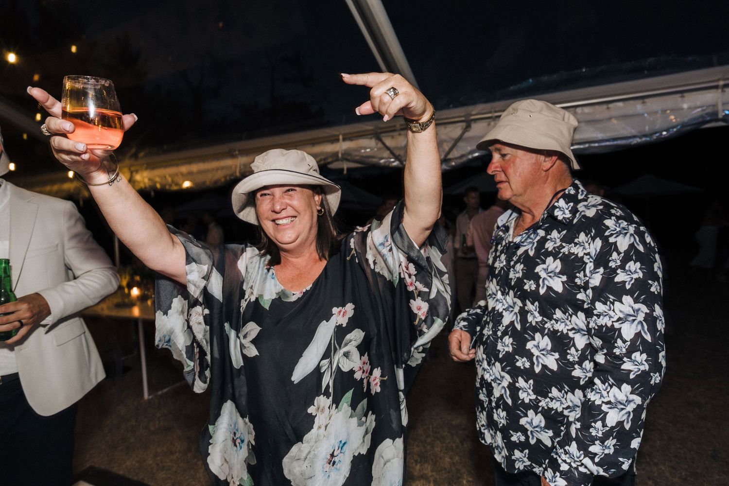 People dancing and celebrating at a nighttime party with dark festive atmosphere.
