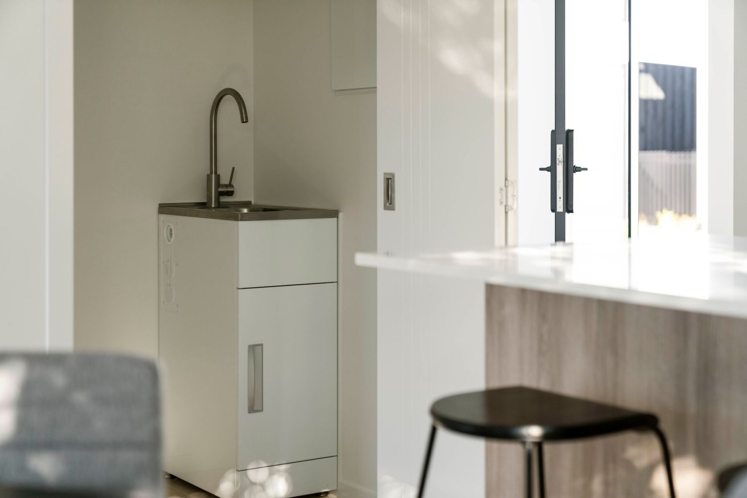 Clean modern bathroom interior with gray and white color scheme featuring walk-in shower and sleek fixtures.
