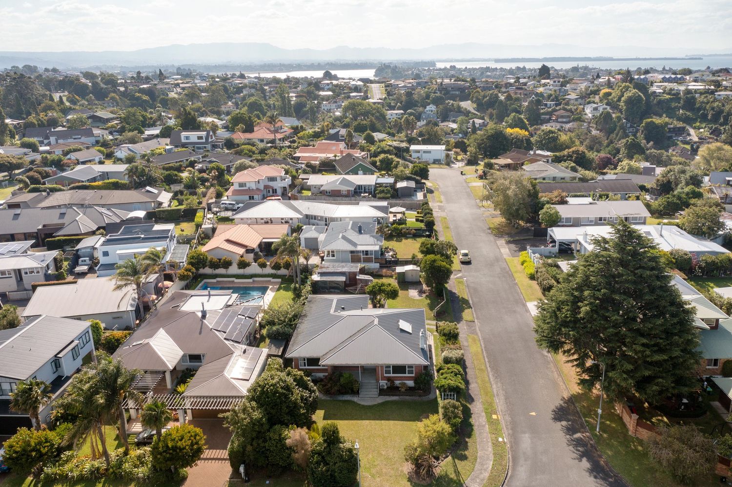 Aerial view of suburban neighborhood with residential houses and streets stretching into the distance.