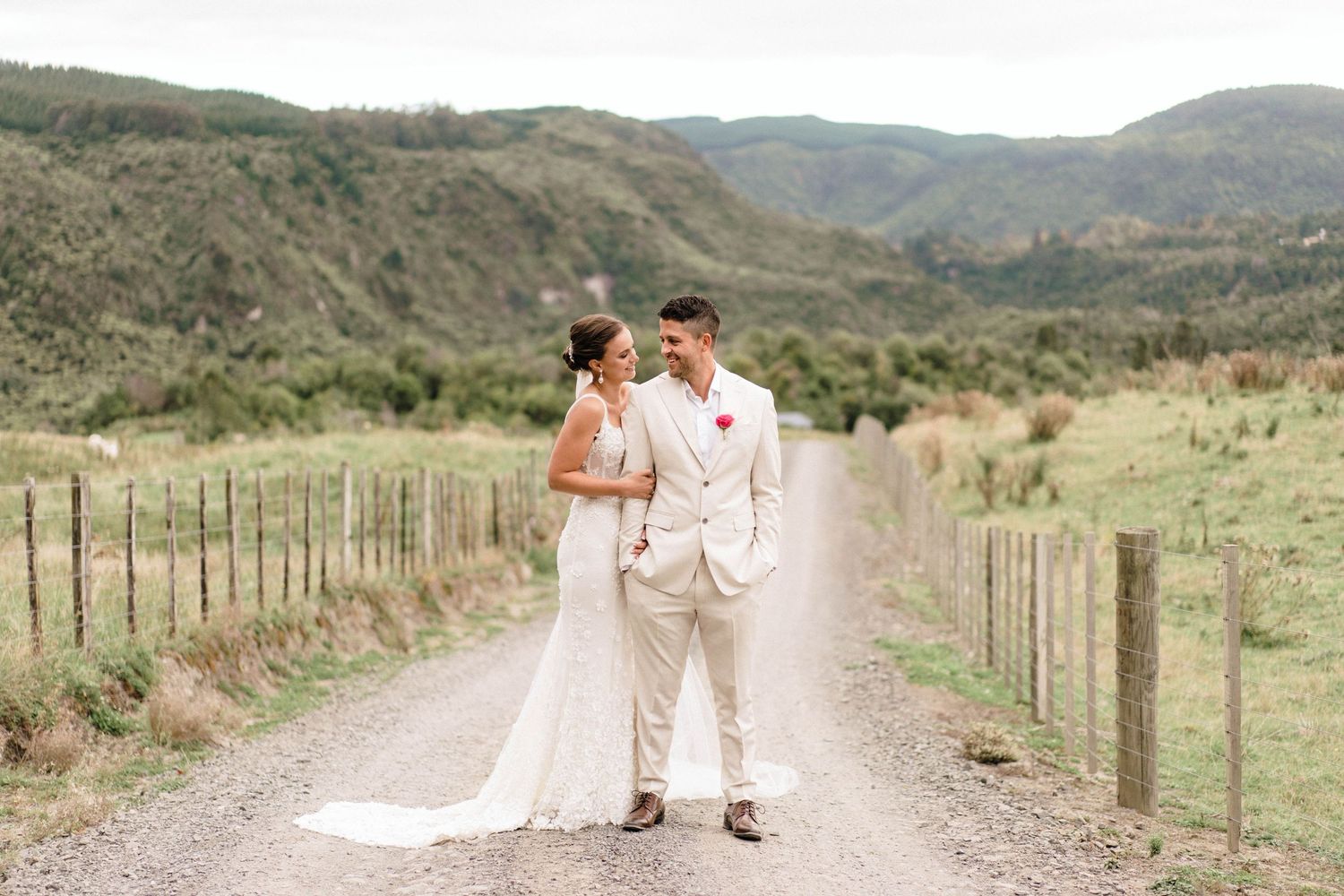Rustic dirt road winding through hills for wedding photos with mountain backdrop.