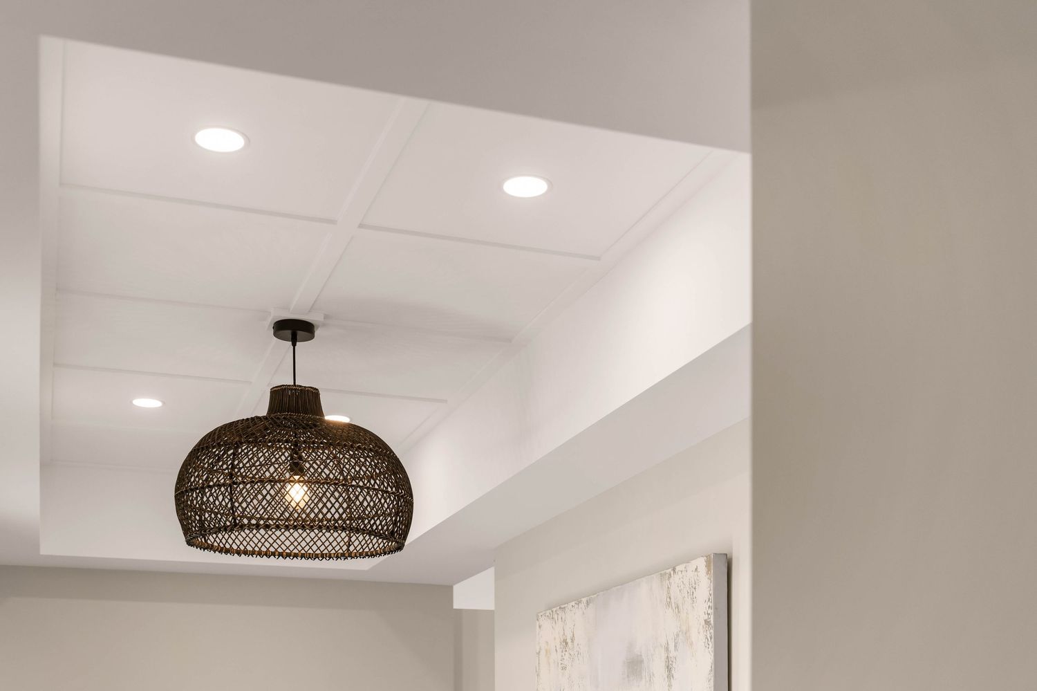 Contemporary white kitchen with minimalist design and pendant lighting fixtures.