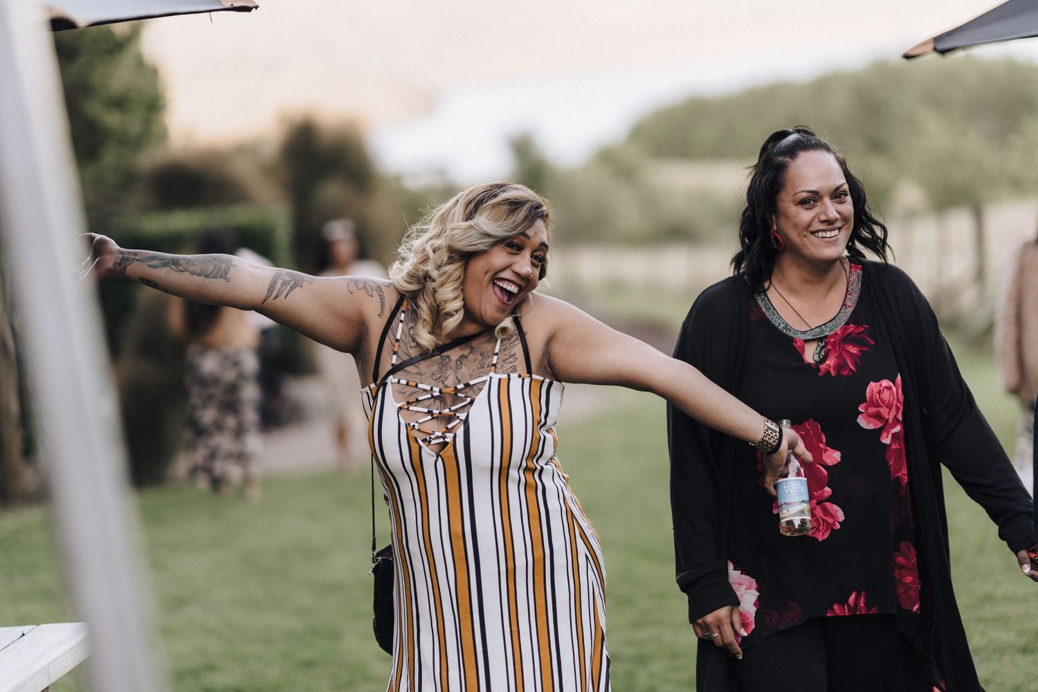 Two women enjoy a playful moment outdoors while walking together on a sunny afternoon.